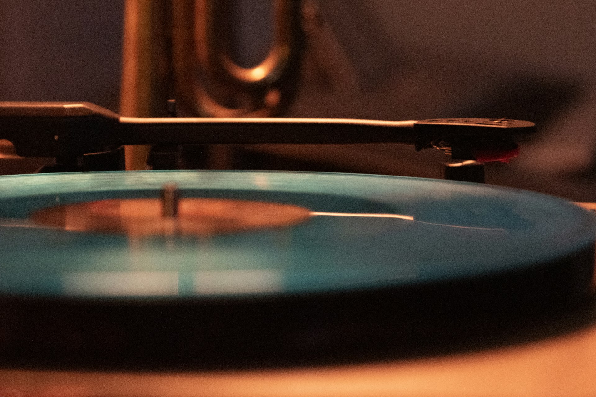 Close-up of a vinyl record on a turntable in warm, dark light
